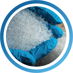 Kraton G polymers in pellet form, being held hands wearing blue gloves.